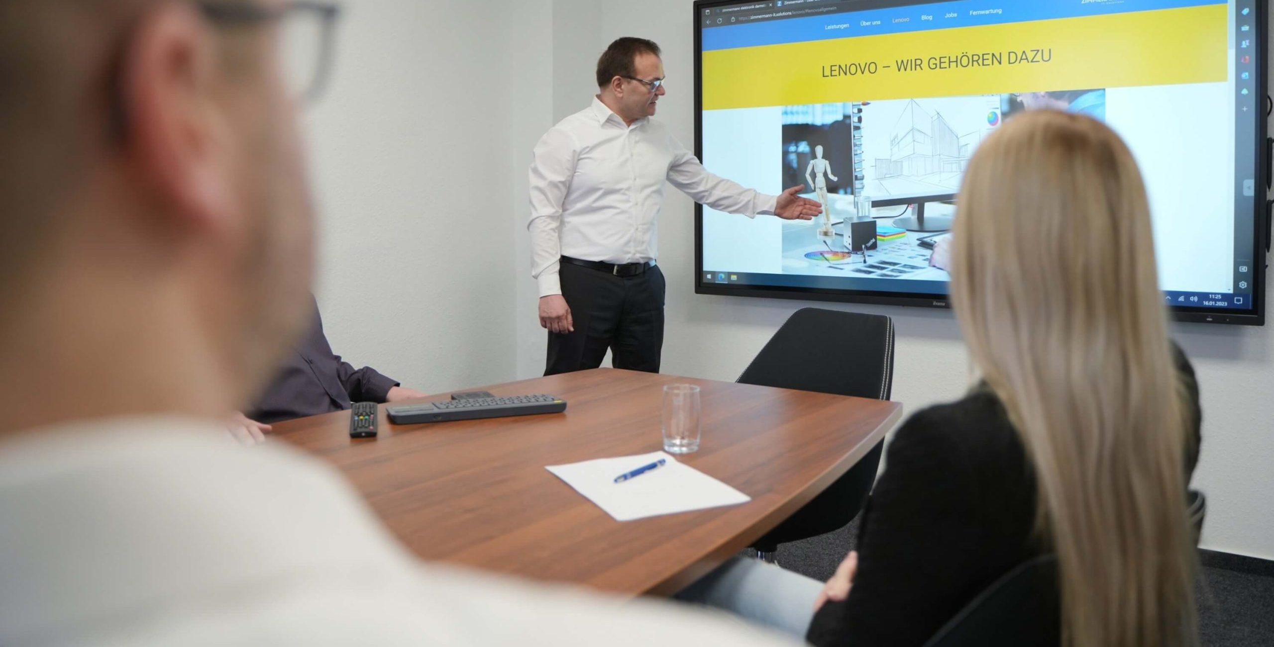 Situationsbild Meetingraum MZ und Mitarbeitern Situationsbild Michael Zimmermann präsentiert die Zimmermann Seite in einem Meetingraum auf einem Smartboard.