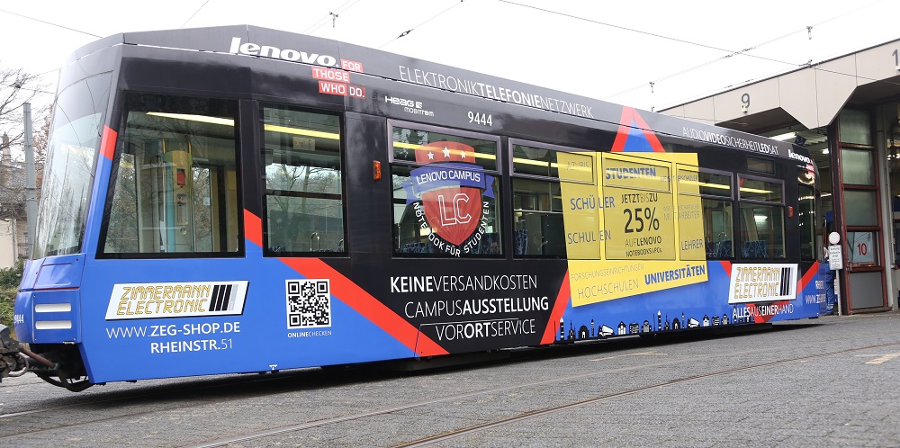 eschrifteter Straßenbahnwagenwaggon mit unserer alten Werbung in Kombination mit Lenovo Campus. Hauptfarben sind blau, schwarz, rot.